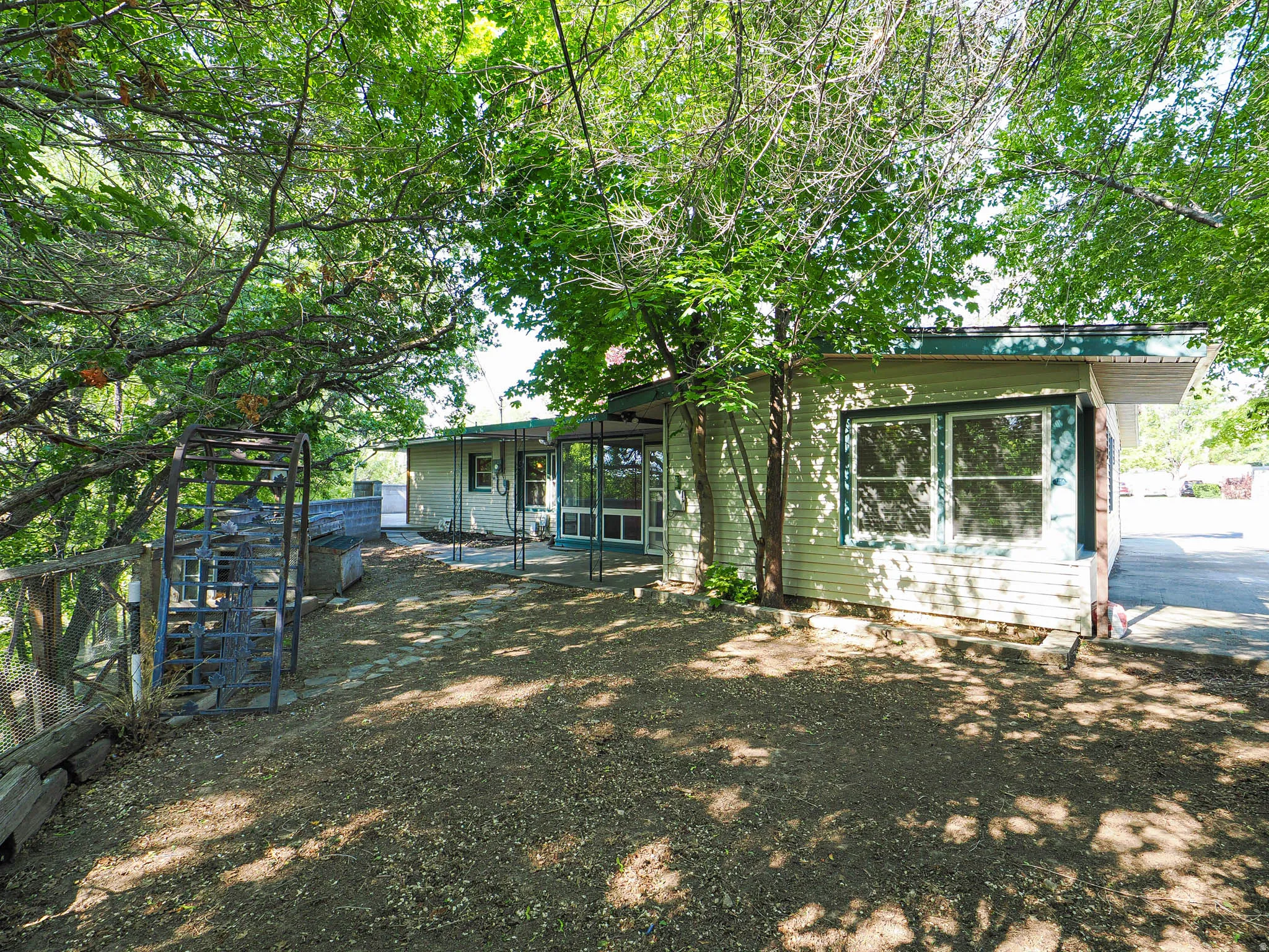 Exterior siding in a light color with dark green trim