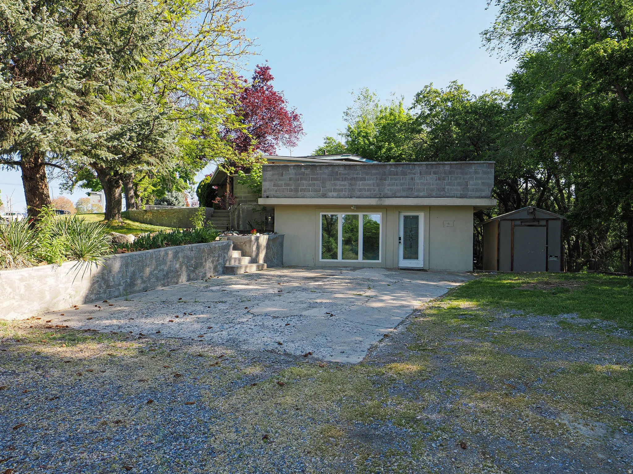 Contemporary-style property featuring a stucco facade and block-style roofline