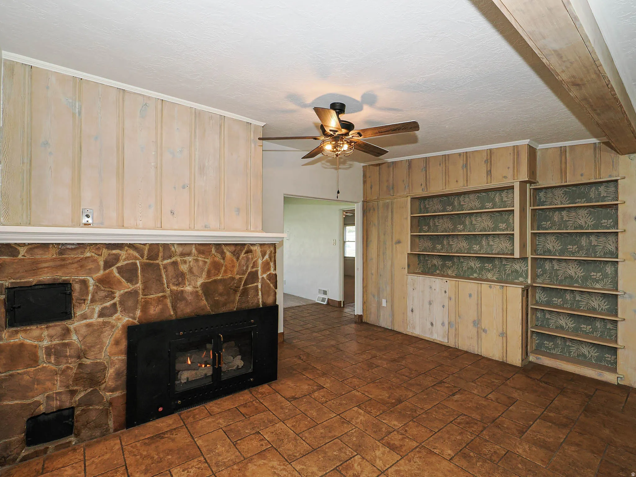 Stone-faced fireplace with a black firebox and hearth