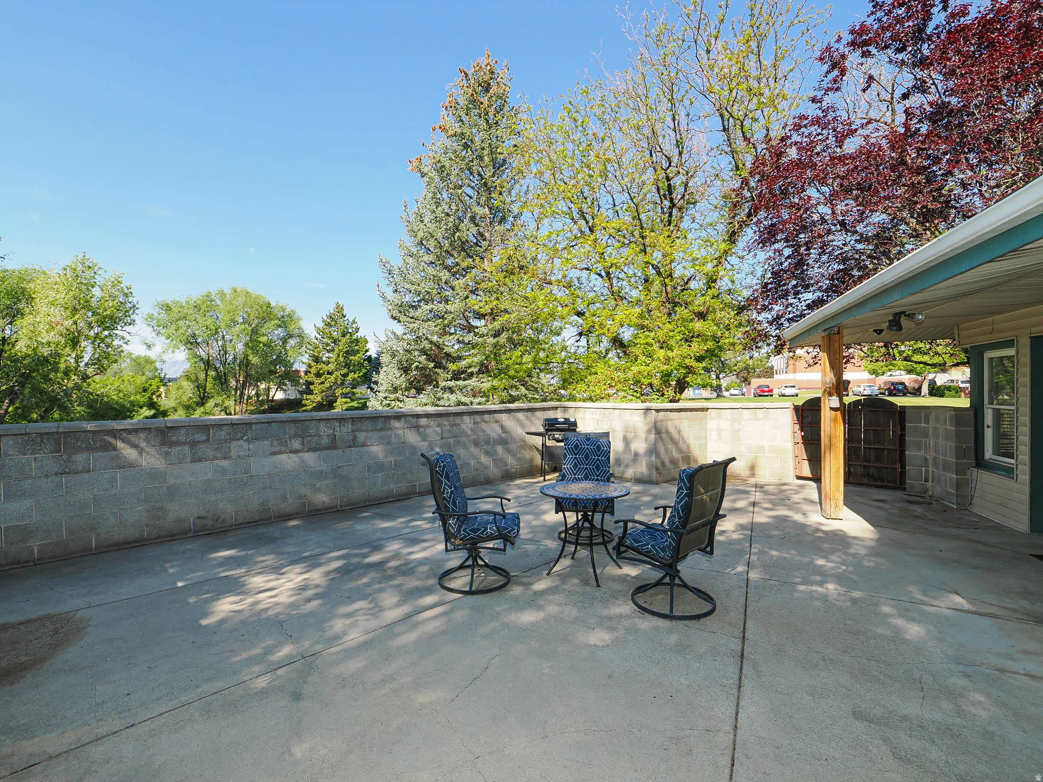 Expansive concrete patio bordered by a block retaining wall