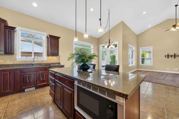 Kitchen island with stone-finish countertop and built-in microwave