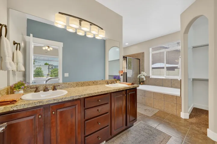Master Bathroom with dual vanity with undermount sinks, granite-look countertop, and dark wood cabinetry