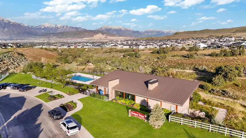 Community amenity building featuring a brown metal roof, stone accents, and an exterior swimming pool