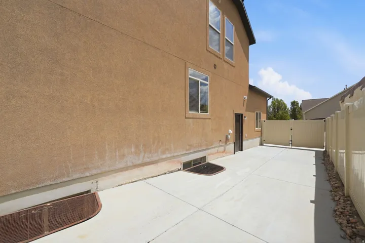 Paved concrete driveway with a privacy fence and a rear access gate