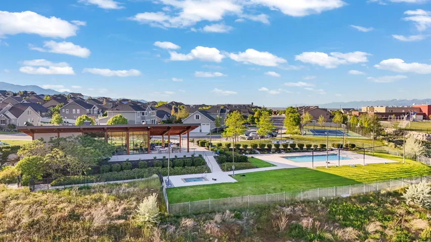 Community amenities featuring a pavilion with outdoor seating, a swimming pool, a separate spa, and a tennis court, all surrounded by landscaped grounds