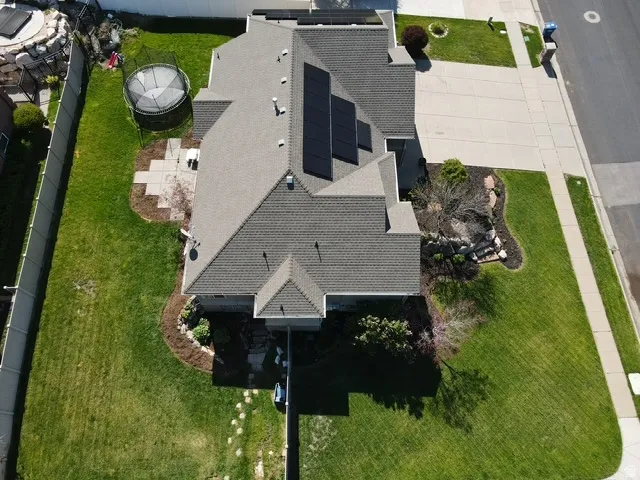 Expansive property featuring a gabled roofline, solar panels, and a concrete driveway