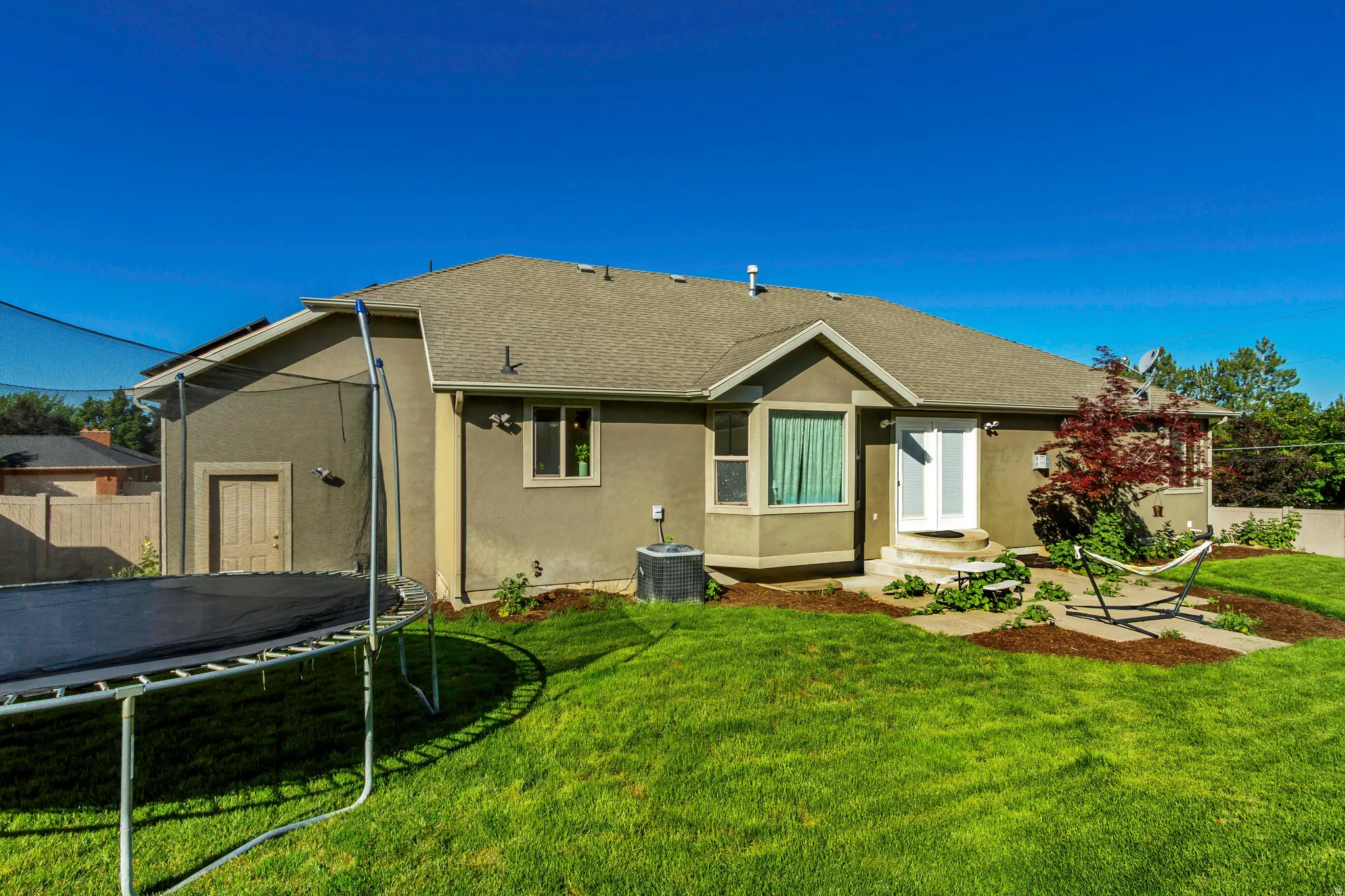 Expansive backyard with manicured lawn and mature landscaping
