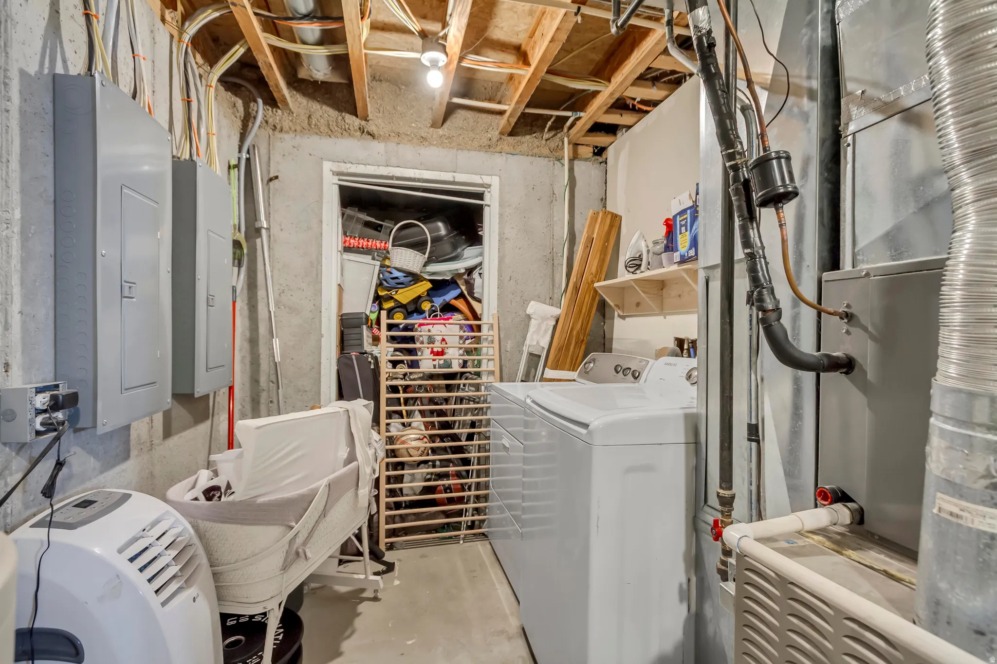 Utility area featuring a washer, exposed ceiling joists, and a furnace with ductwork
