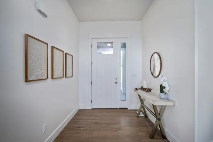 Entryway featuring a white door with glass panels, a full-length sidelight, wood-finish flooring, and crisp white walls