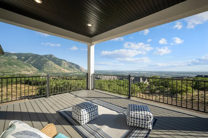 Expansive covered deck featuring composite decking, recessed lighting, and a metal railing system