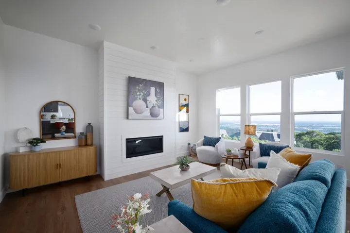 Living area featuring multiple large windows, a built-in electric fireplace with shiplap surround, wood-finish flooring, and recessed ceiling lighting