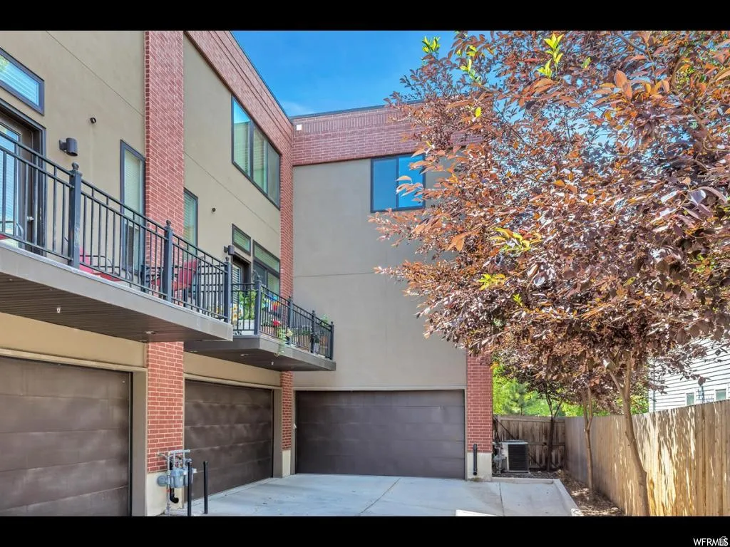 Multi-story townhome exterior featuring contemporary design with brick accents and stucco siding