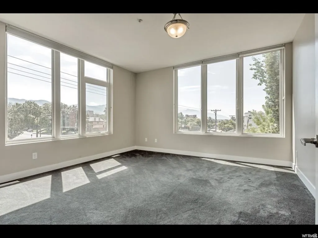 Room featuring expansive windows with roller shades