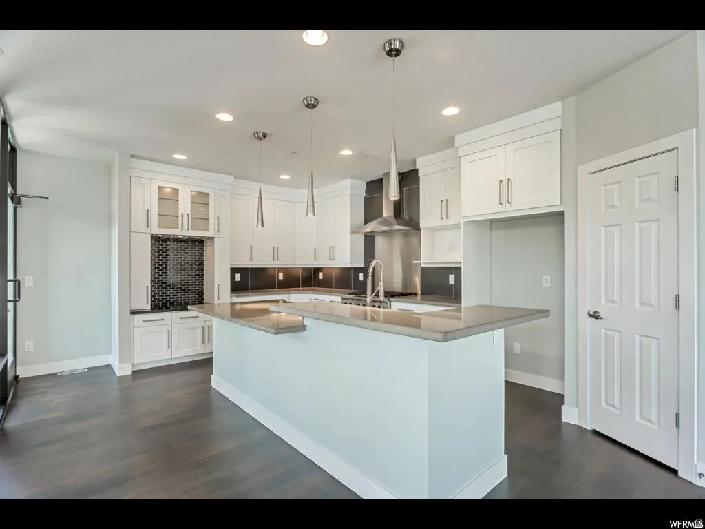 Modern kitchen featuring an expansive center island with a stone-finish countertop