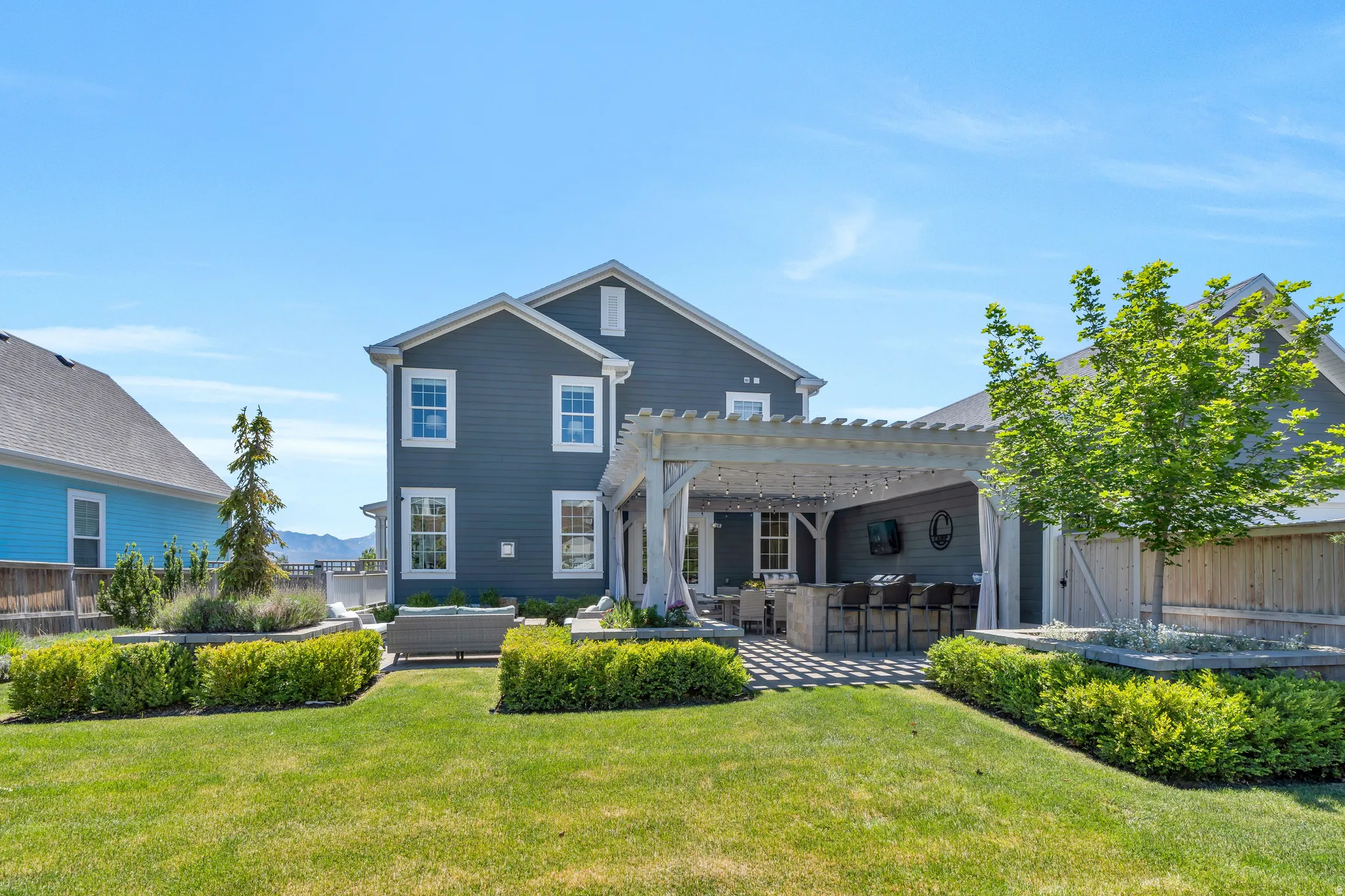Stunning luxurious yard featuring ample grass areas, mature landscaping and pergola covered picnic grilling area