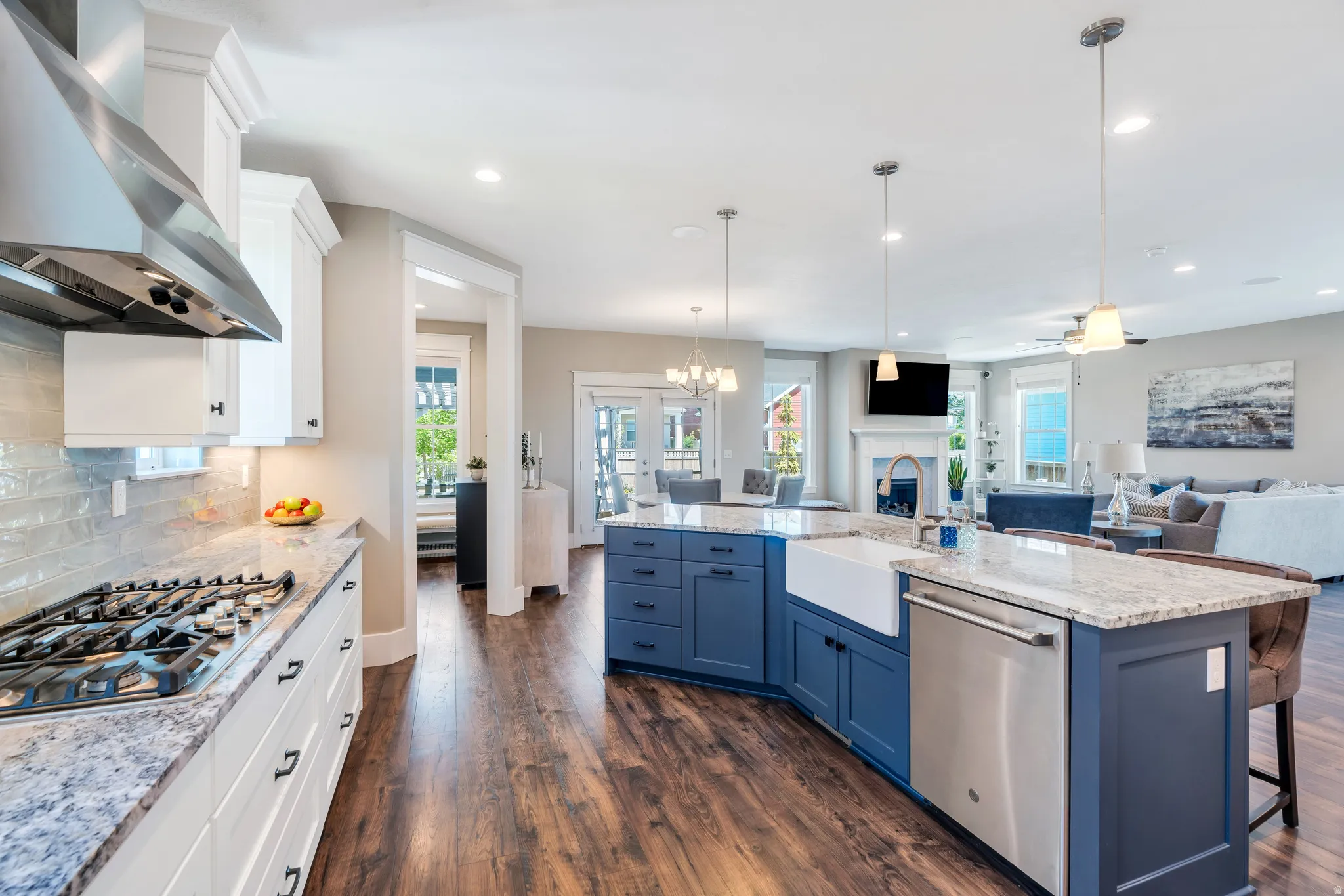 Stunning open concept kitchen featuring generous island, chef stove, and pendant lighting