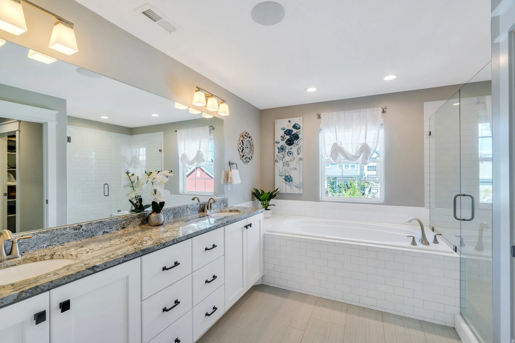 Stunning ensuite features generous dual granite vanity, soaking tub, and euro shower