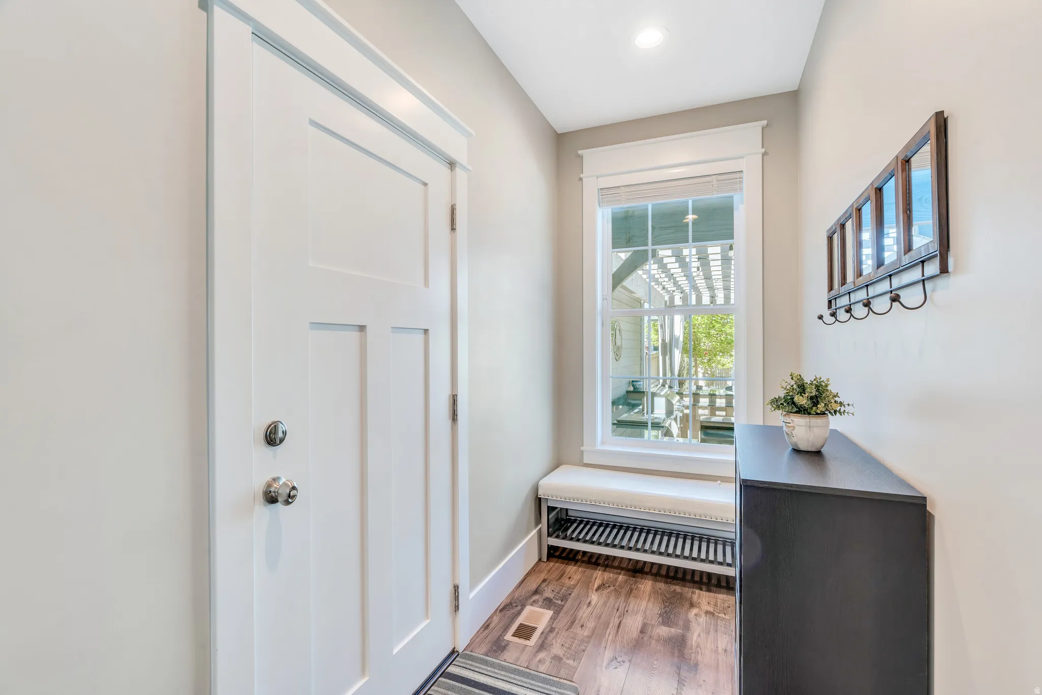 Mudroom style garage entry with window seating and space for coats and shoe storage