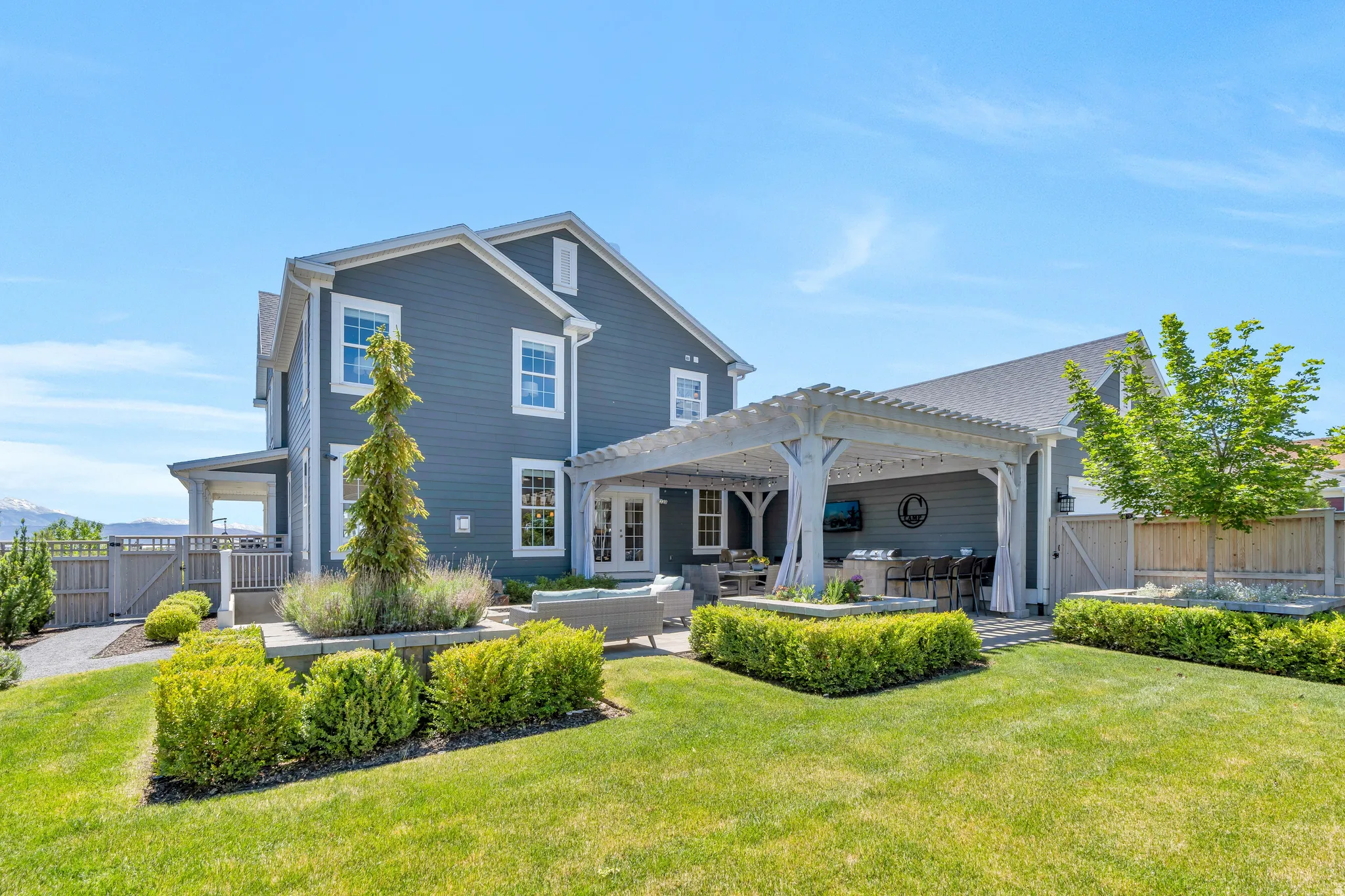 Enchanting backyard with gorgeous greenery, spacious yard, and picnic grilling area, and firepit