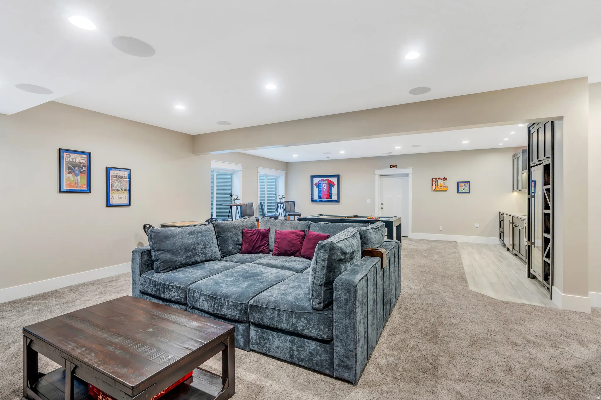 Generous family room featuring raised ceilings, ceiling speakers, and kitchenette perfect for entertaining