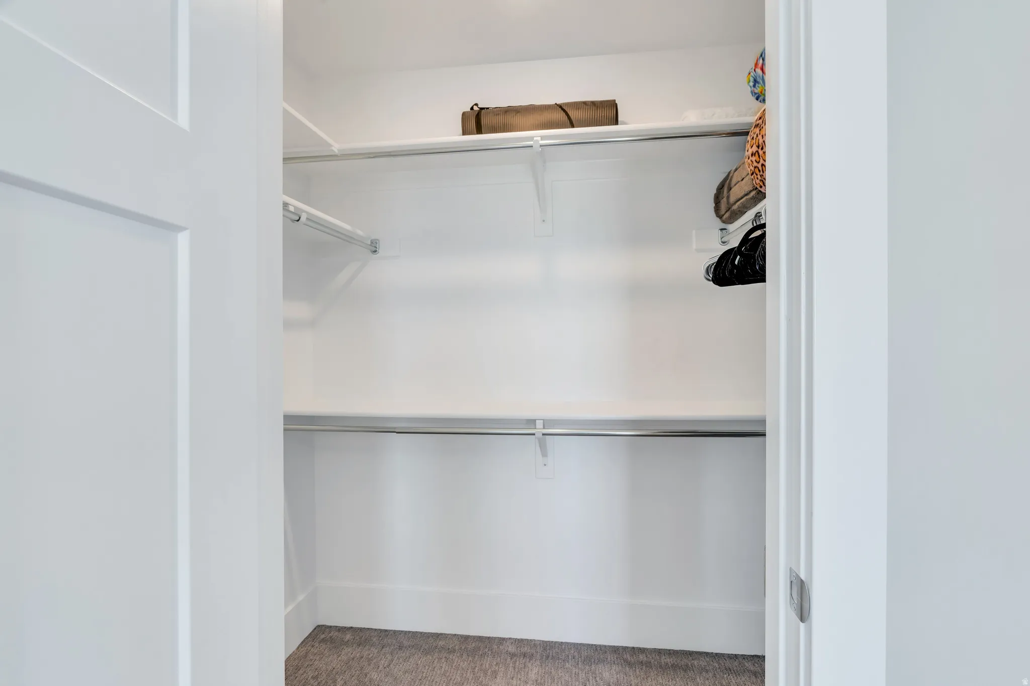 Spacious upper level bedroom closet with ample clothing racks and storage space