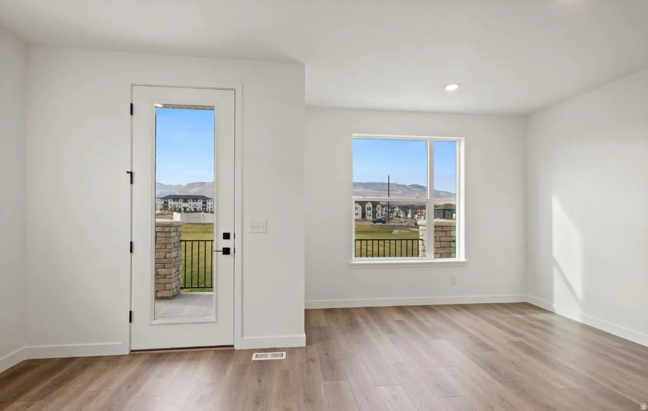 Bright interior space featuring wood-finish flooring and a full-light exterior door