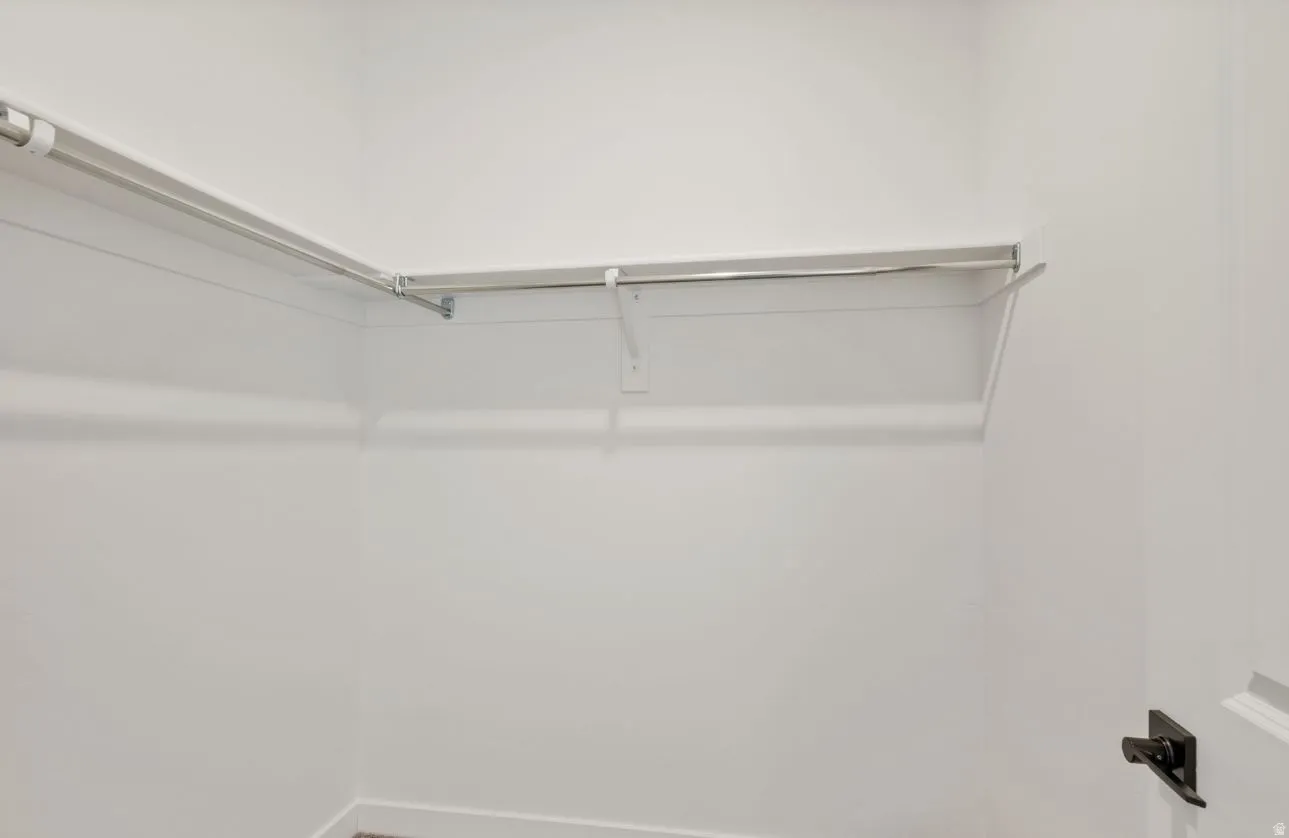 White interior closet featuring a garment rod, upper shelf, and painted walls