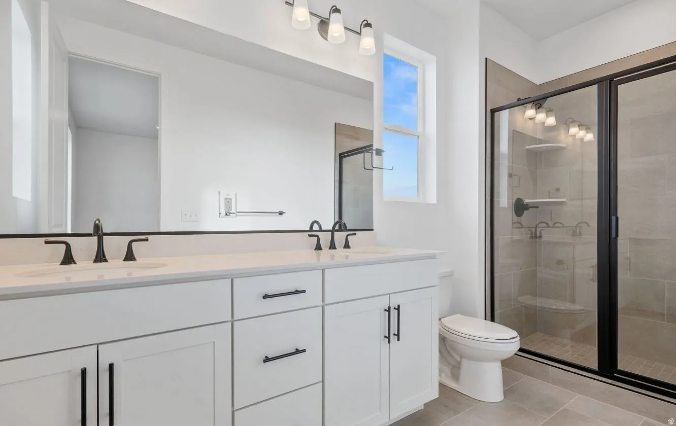 Double vanity with white cabinetry, matte black hardware, and an expansive mirror