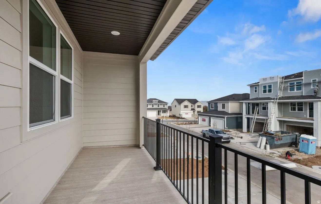 Private balcony featuring textured concrete flooring and a dark metal railing