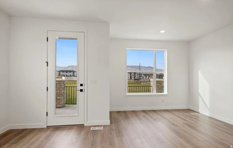 Bright interior space featuring wood-finish flooring and a full-light exterior door