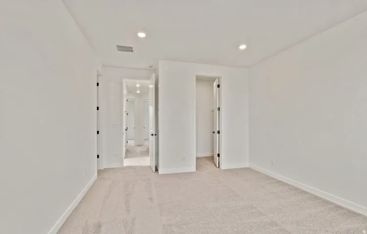 Neutral-toned carpeting defining an interior space with a recessed lighting fixture