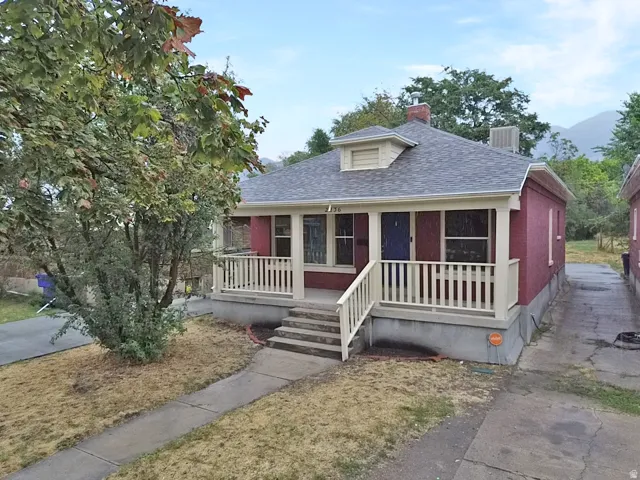 Brick exterior with a covered porch and white railing, featuring a blue entry door
