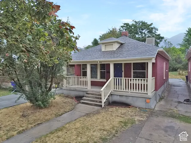 Brick exterior with a covered porch and white railing, featuring a blue entry door