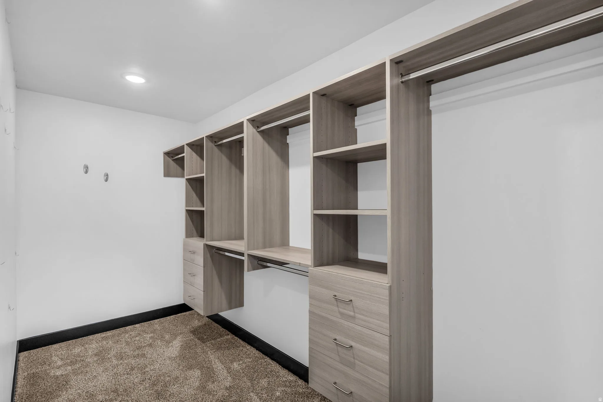 Built-in closet system featuring multiple shelving units, hanging rods, and integrated drawers