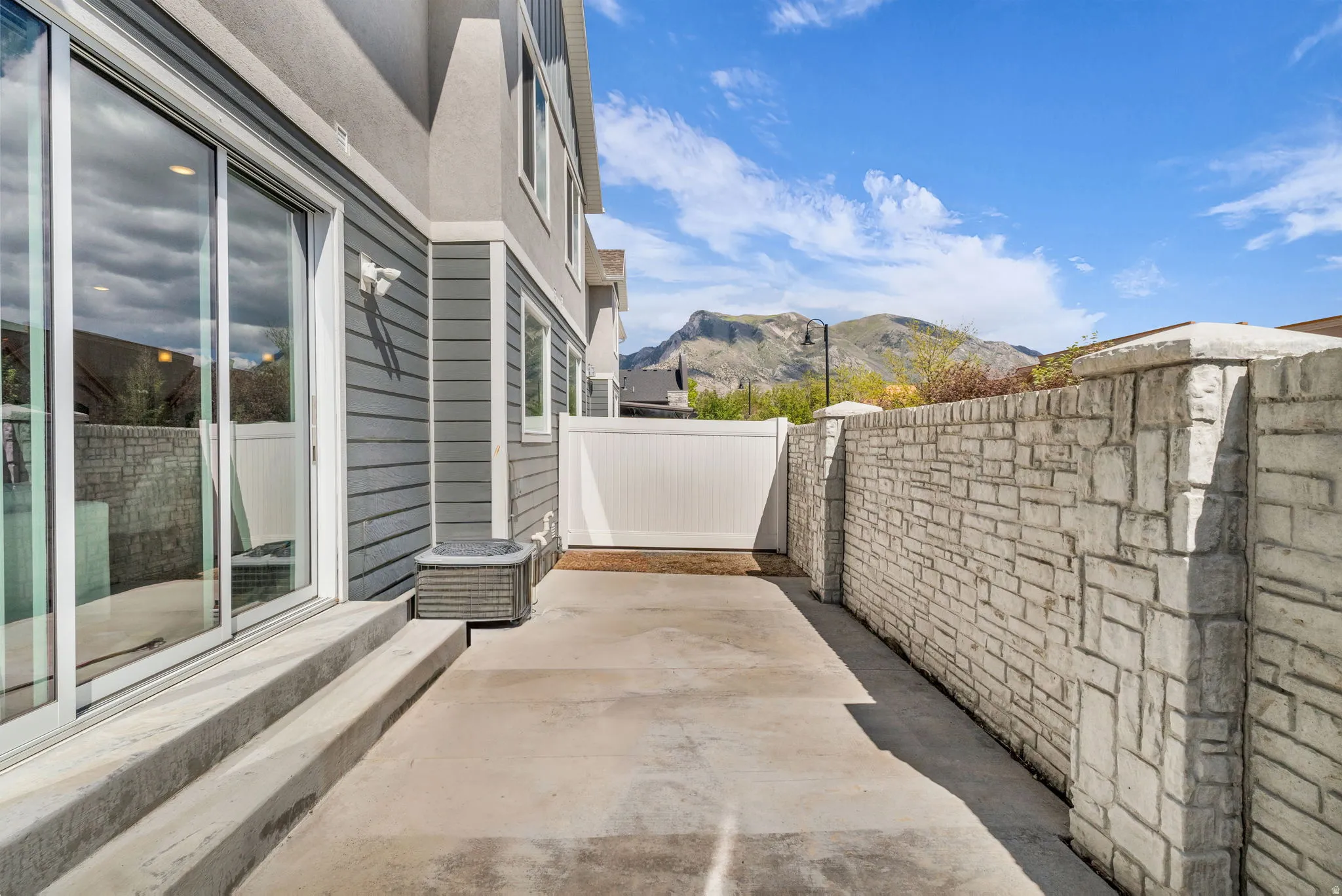 Private patio featuring concrete flooring and a stone-style privacy wall