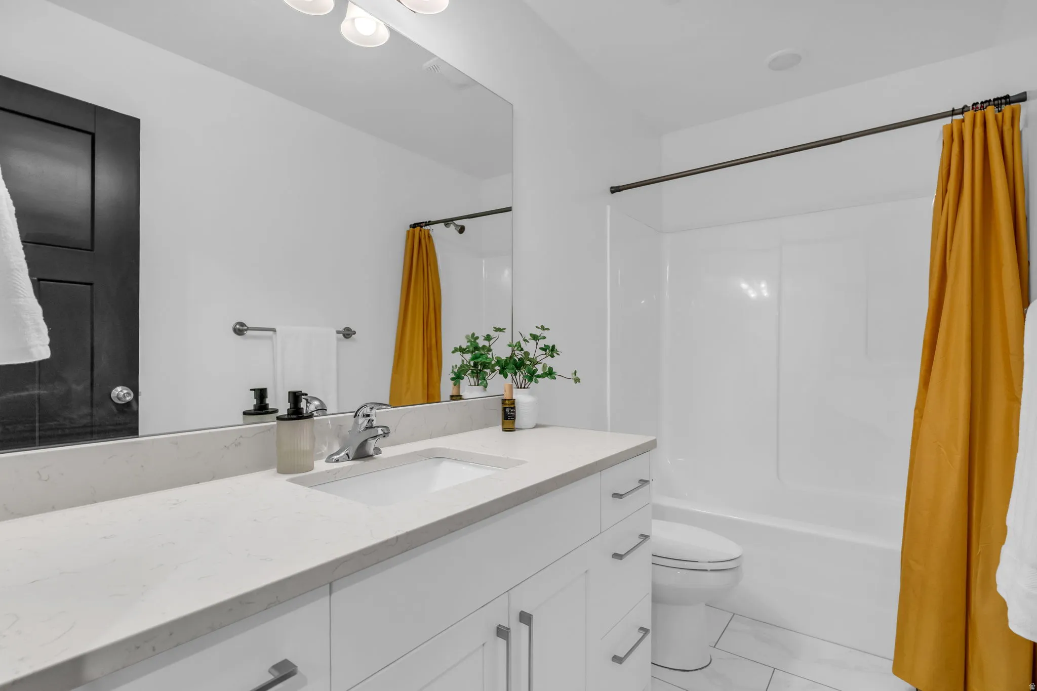Modern bathroom featuring a white vanity with an integrated sink, a light-toned countertop, and silver-tone hardware