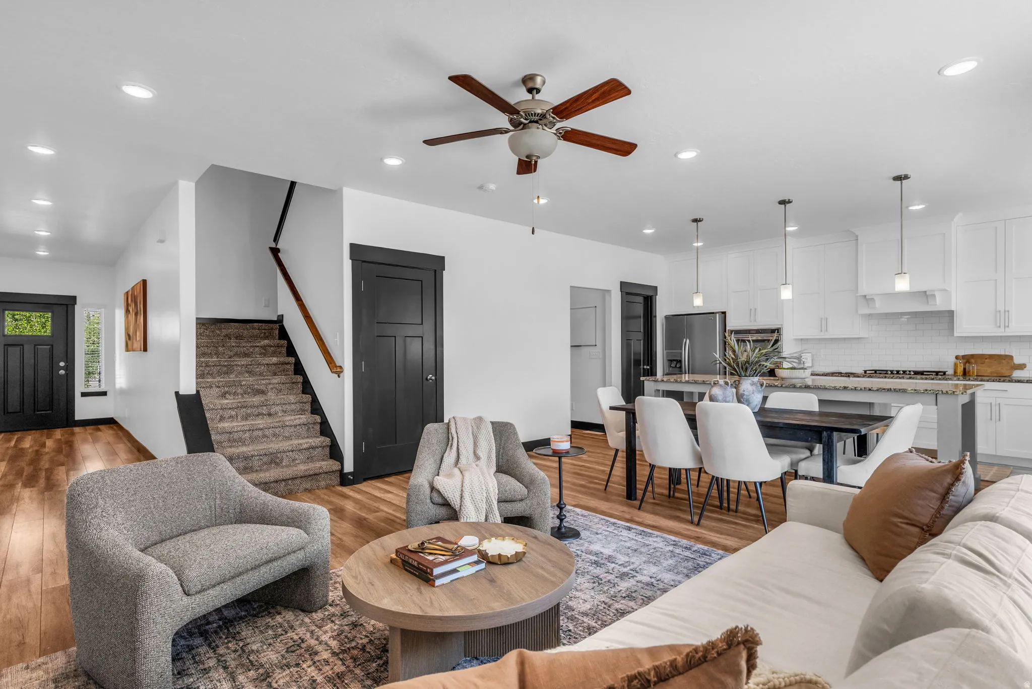 Open-concept living space featuring wood-finish flooring, recessed lighting, and a ceiling fan