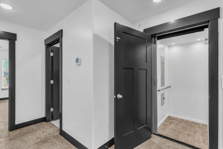 Integrated residential elevator featuring a grab bar and recessed lighting