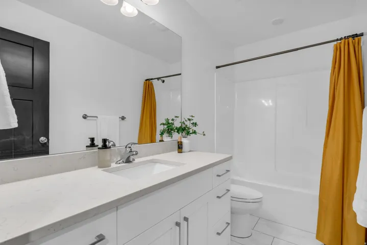Modern bathroom featuring a white vanity with an integrated sink, a light-toned countertop, and silver-tone hardware