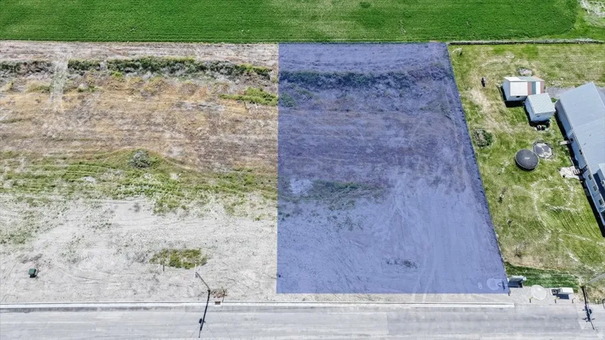Expansive undeveloped land parcel featuring a clear street frontage and surrounding green spaces