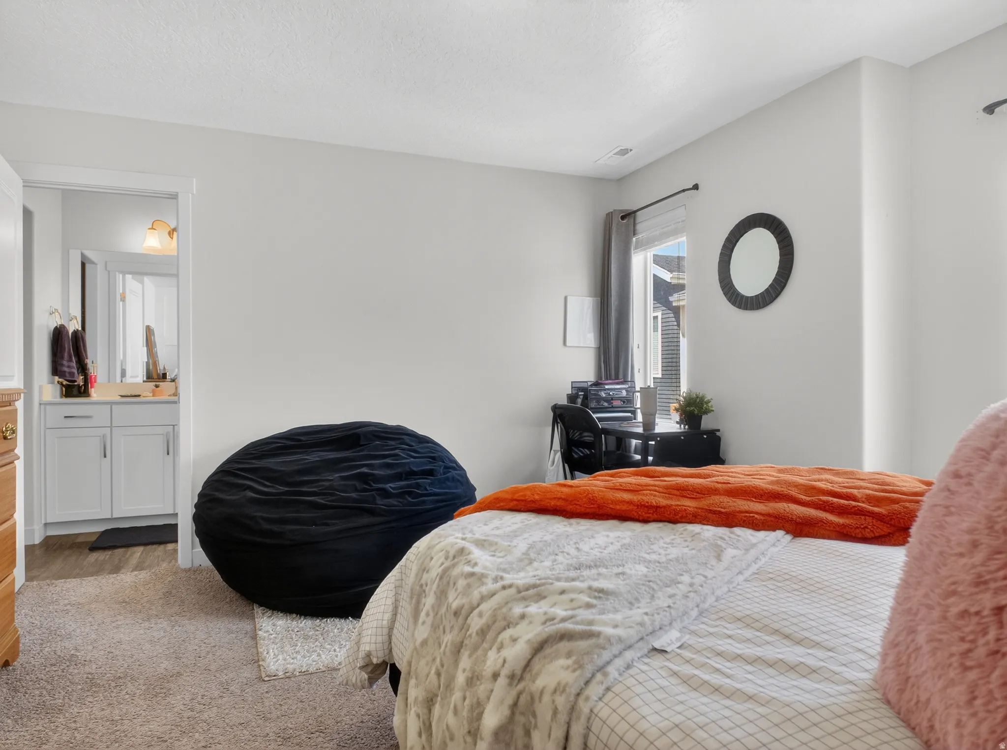 Carpeted room with light neutral walls and a window providing natural light