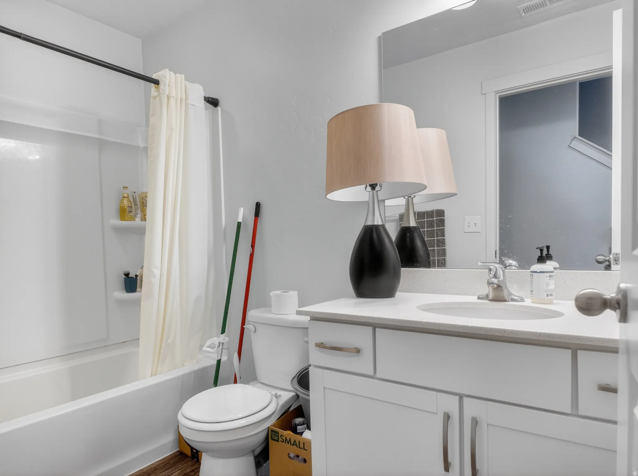 Bathroom featuring a white vanity with a stone-finish countertop, undermount sink, and brushed nickel hardware