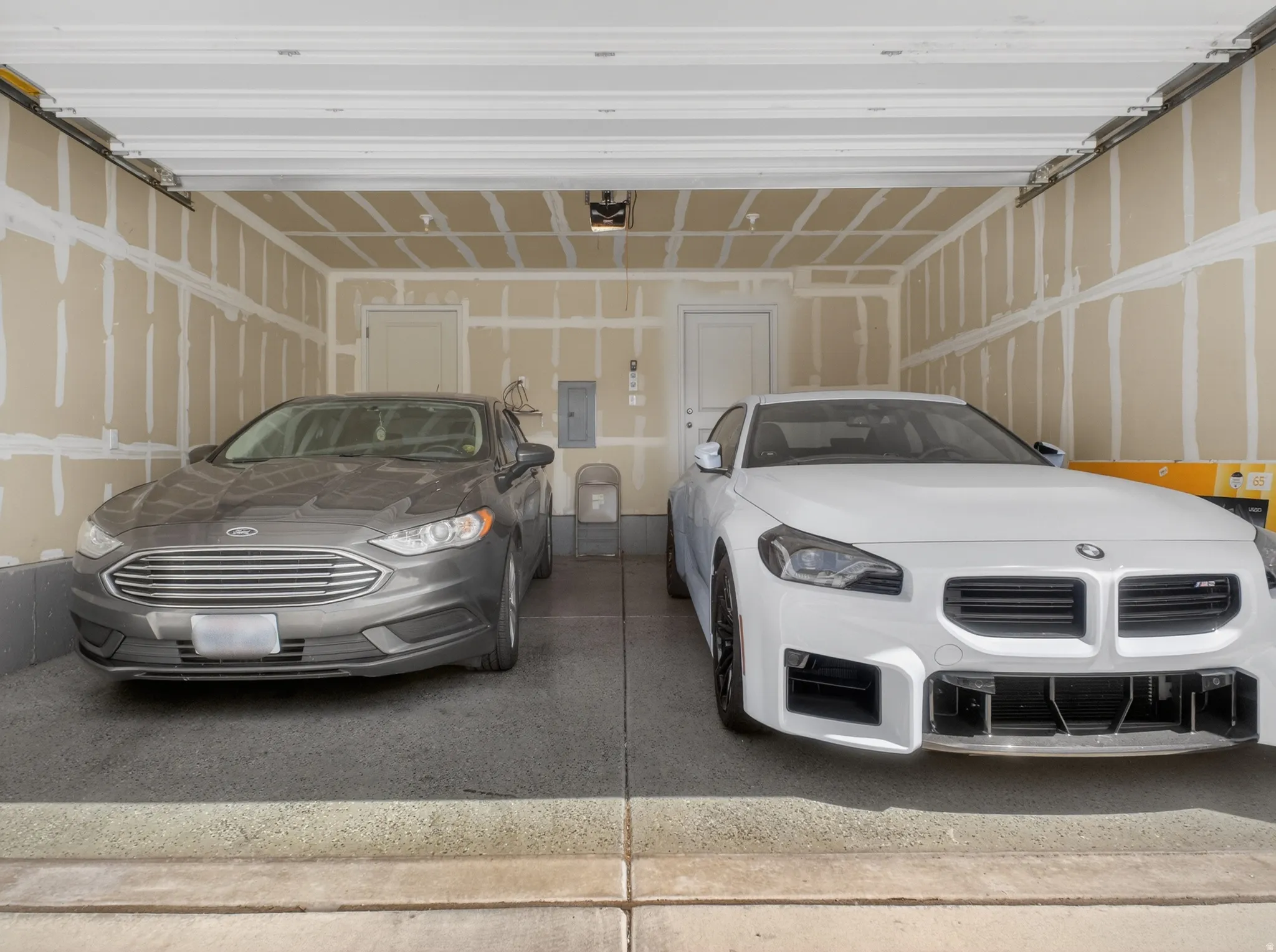 Two-car garage featuring an epoxy-coated concrete floor and interior access door