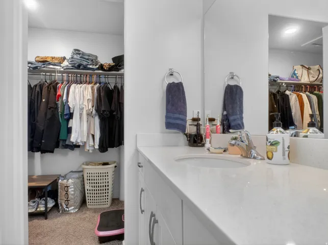 Double vanity with undermount sinks, chrome faucets, and light-toned countertops