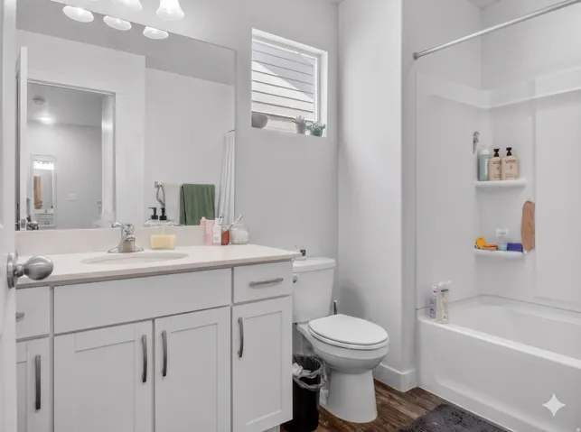 Bathroom featuring a light-toned countertop vanity with white cabinetry, a single basin sink, and a large wall-mounted mirror