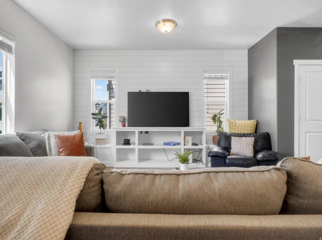 Living area featuring white shiplap accent wall, recessed lighting, and built-in media console