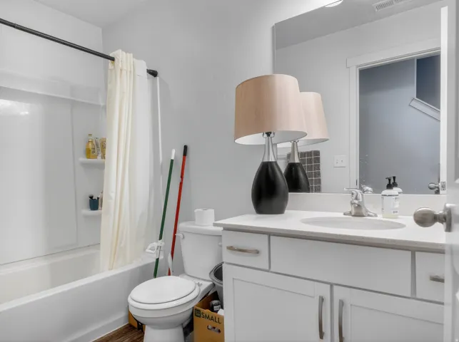 Bathroom featuring a white vanity with a stone-finish countertop, undermount sink, and brushed nickel hardware