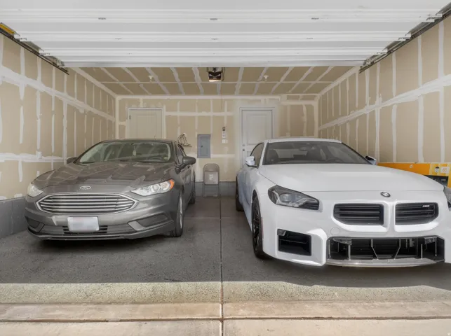 Two-car garage featuring an epoxy-coated concrete floor and interior access door