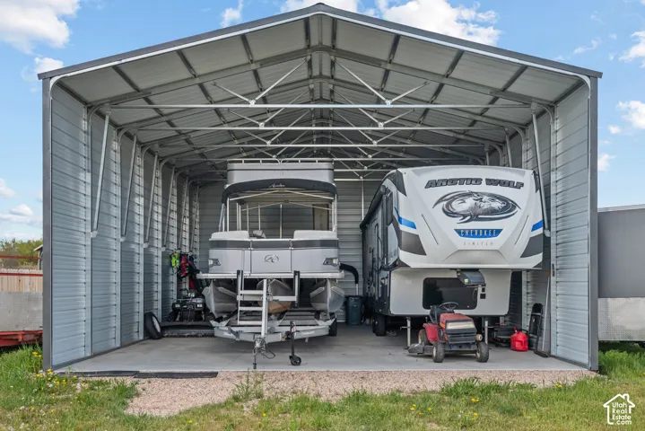Spacious metal carport structure with a durable concrete pad, offering ample covered storage