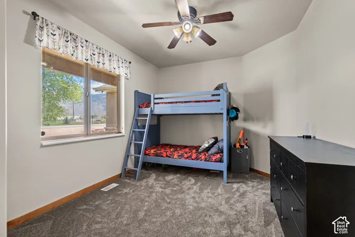 Room featuring neutral painted walls, gray textured carpet, and a wood-finish baseboard